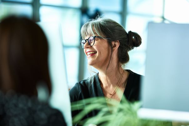 An office worker smiling at their computer screen.